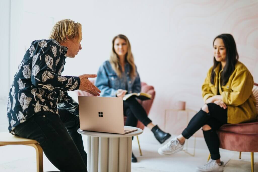 Trainer w/ two trainees looking at a laptop together