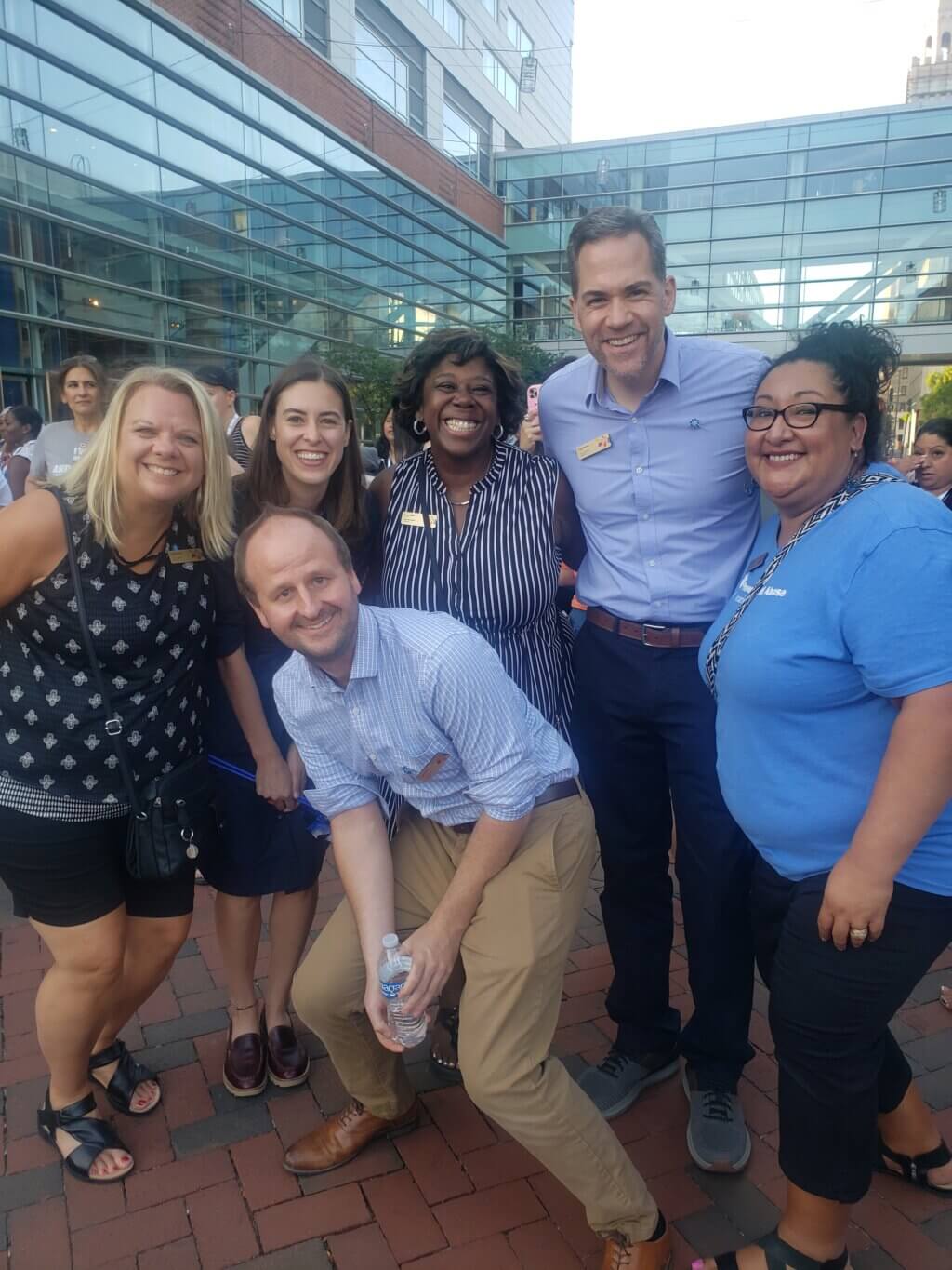 National Office team members smile, posing together at an outdoor event.