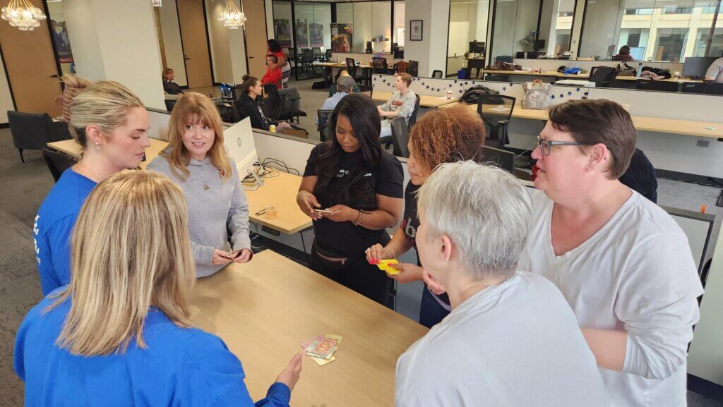 HFA team members surround a table, concentrated on a task at hand